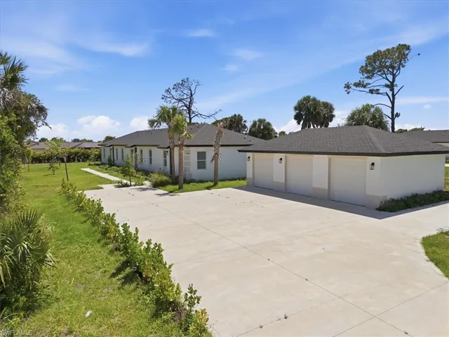 Expansive concrete driveway with a three-car garage structure