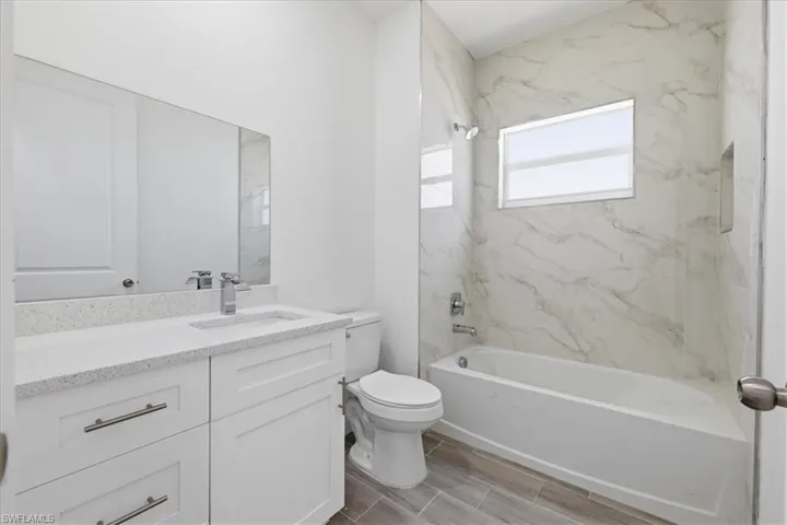 Bathroom featuring a white vanity with a light-toned countertop, a rectangular sink with a chrome faucet, and a large mirror