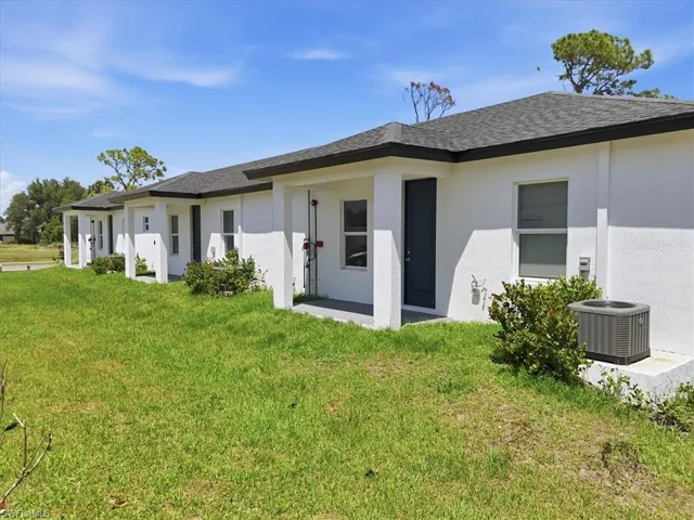 New construction exterior with white stucco finish and dark gray shingle roofing