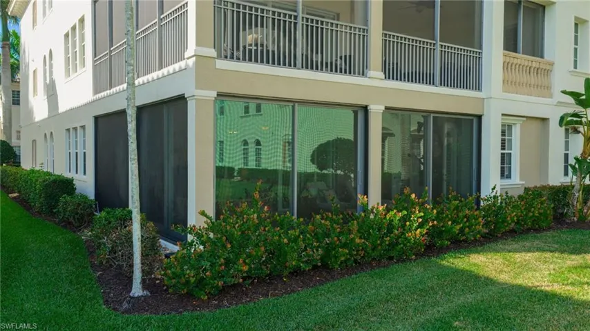 View of side of property with stucco siding, a yard, and a balcony