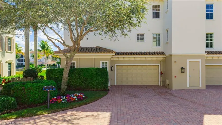 View of front facade with stucco siding, a garage, decorative driveway, and a tiled roof