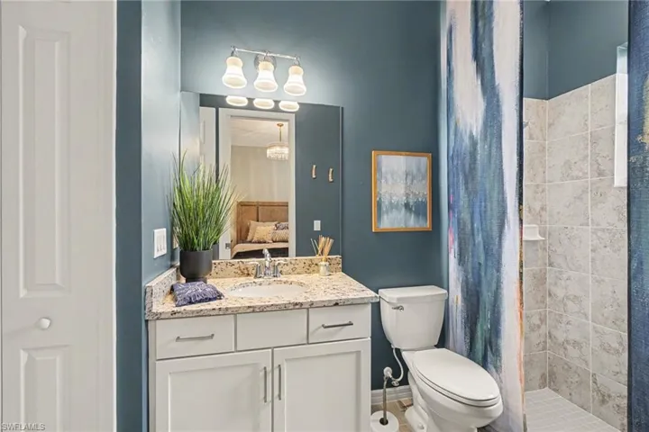Vanity with a light-toned countertop, under-mount sink, and white cabinetry