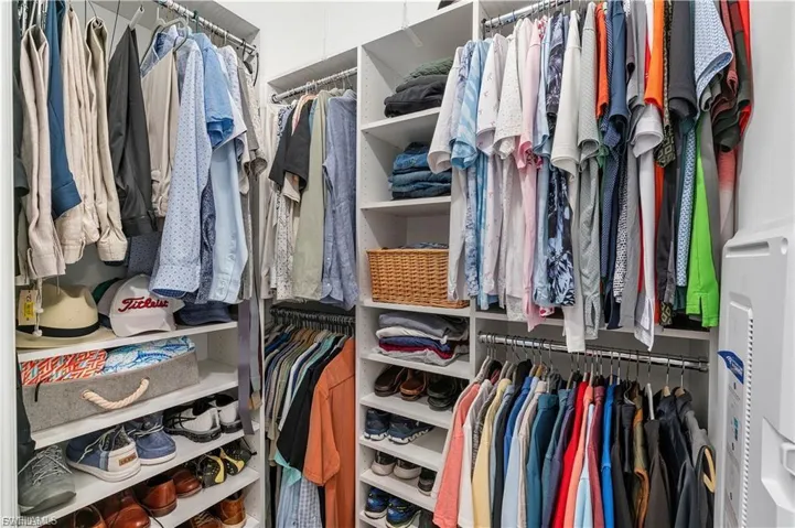Built-in custom closet system with multiple hanging rods, integrated shelving, and shoe storage