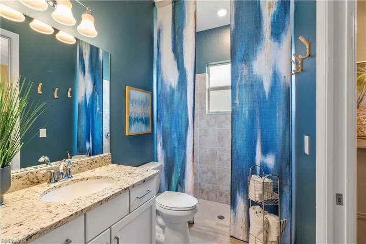 Vanity with an undermount sink, a chrome faucet, and a stone countertop
