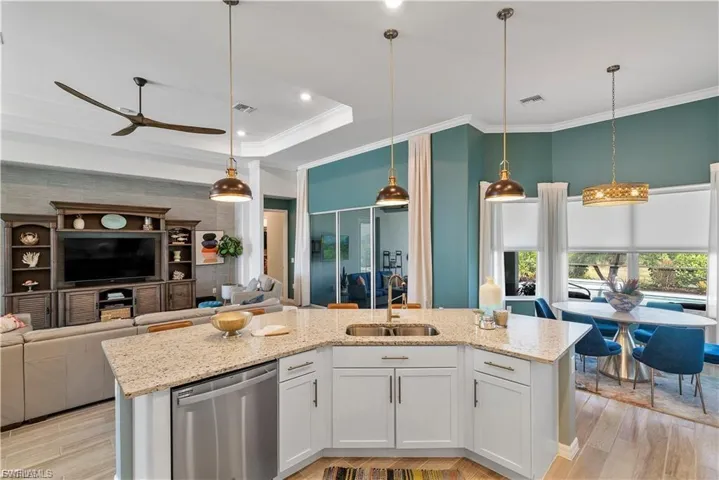 Well-appointed kitchen island with light-toned countertop, stainless steel dishwasher, and under-mount sink