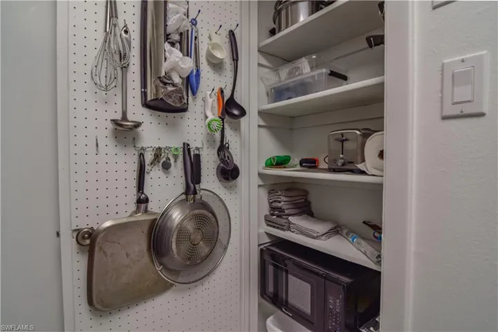 Kitchen with pantry closet equipped with additional small appliances, cookware, and additional room for storage