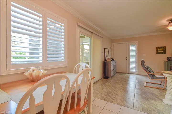 Dining area looking into living area, impact glass sliders with window treatment - onto new white aluminum Florida room
