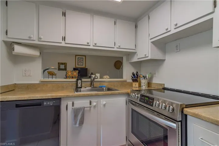 Kitchen featuring stainless steel range with electric cooktop, NEW black dishwasher, white cabinets, and stainless steel sink