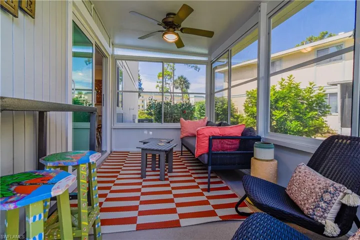 Sunroom featuring ceiling fan, whimsical furnishings and artwork