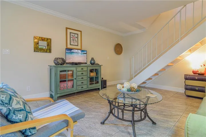 Living room featuring crown molding and tile patterned floors