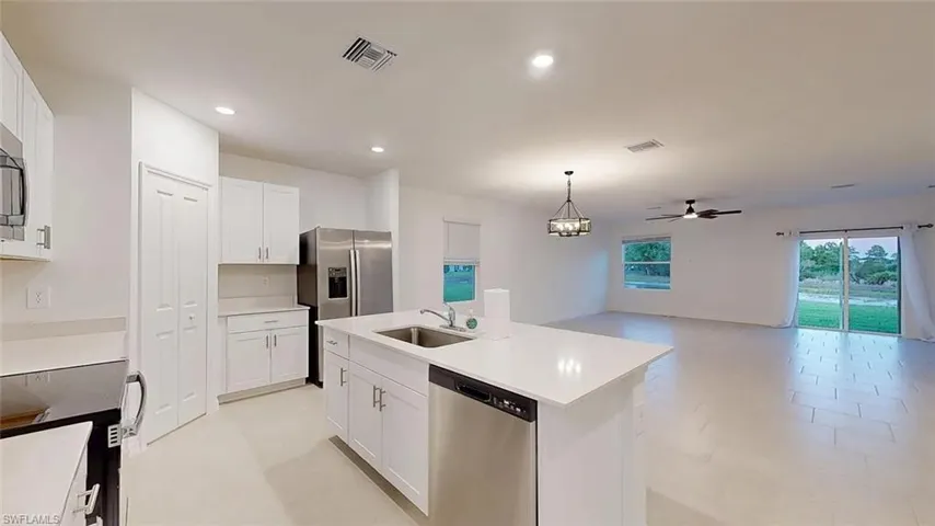 Open-concept living area with white walls and light-toned tile flooring