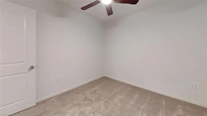 Neutral wall finishes with a ceiling fan and carpeted flooring