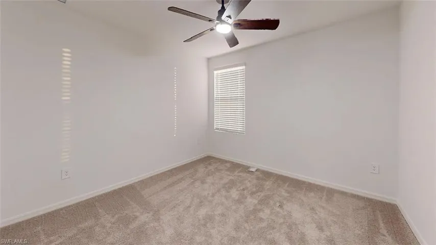 Neutral-toned carpeting, window with blinds, and a ceiling fan with integrated lighting