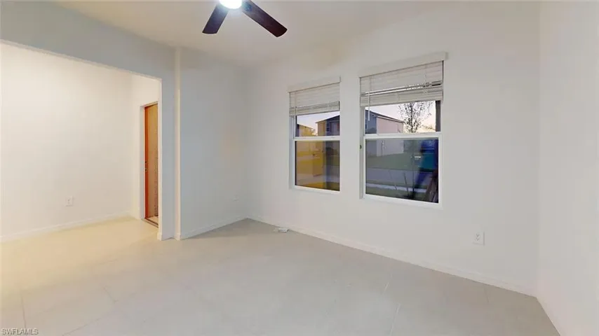 Bright interior with neutral-toned flooring, white walls, and a ceiling fan