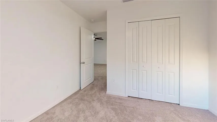 Plush carpeting, crisp white walls, and a bi-fold closet door