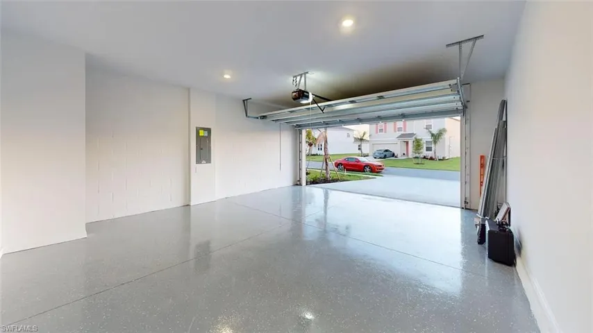 Attached garage featuring a durable epoxy-coated concrete floor, recessed lighting, and an automatic garage door opener