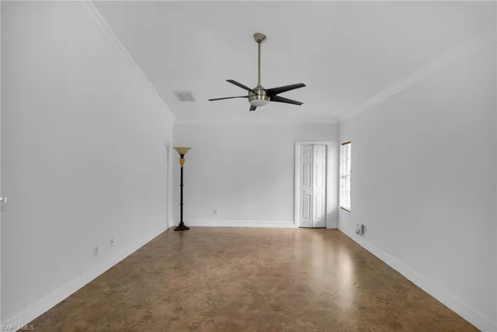Spare room featuring ceiling fan and ornamental molding