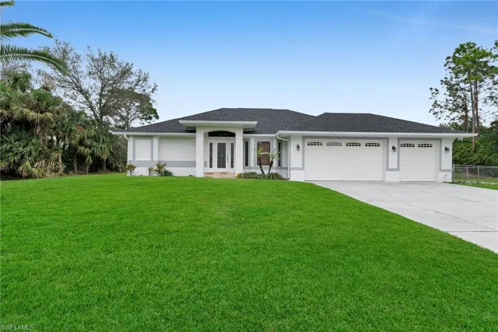 View of front facade featuring a front lawn and a garage