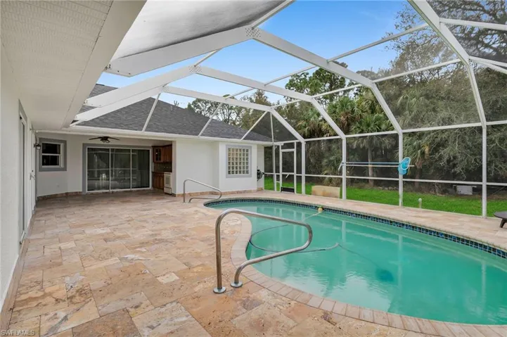View of swimming pool featuring a lanai, ceiling fan, and a patio area