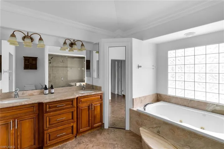 Full bathroom with toilet, crown molding, separate shower and tub, and vanity