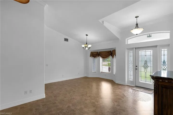 Entryway with crown molding and a chandelier