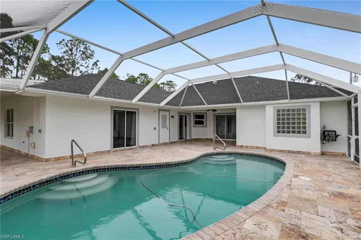 Back of property featuring a lanai and a patio