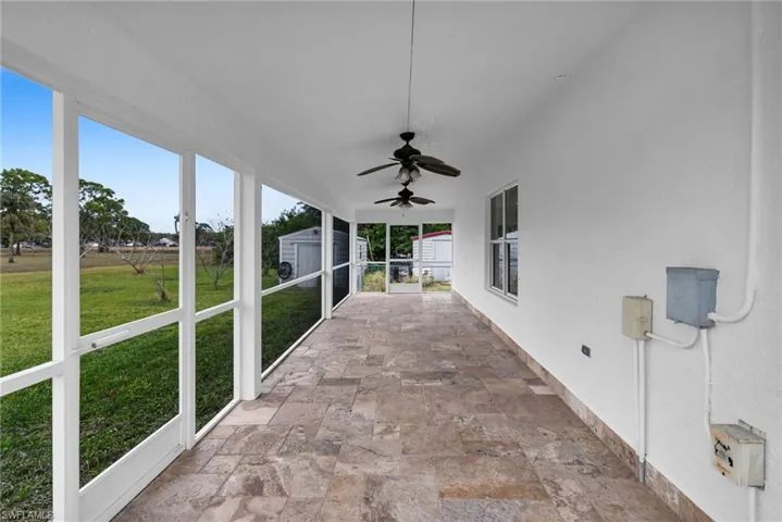 Unfurnished sunroom featuring ceiling fan