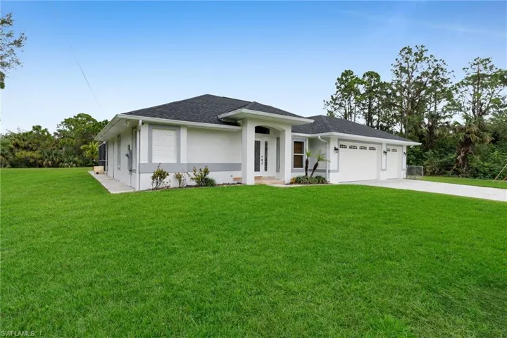 View of front of property with a front yard and a garage