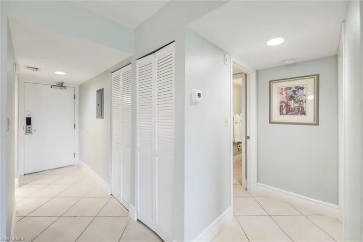 Hall featuring light tile patterned flooring, recessed lighting, and electric panel