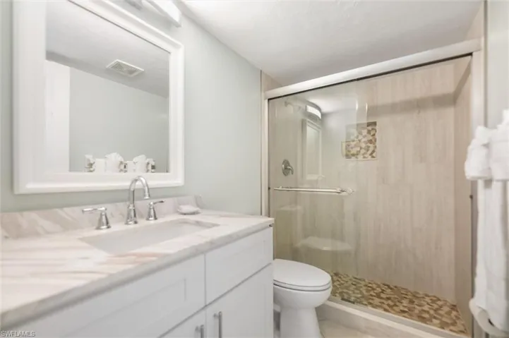 Full bathroom with vanity and a shower stall