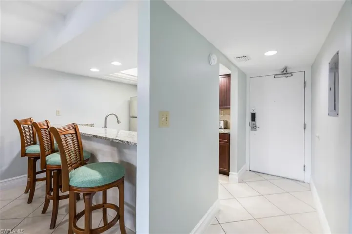 Corridor featuring light tile patterned floors, electric panel, and recessed lighting