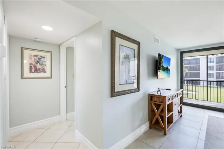 Hall featuring light tile patterned floors and baseboards
