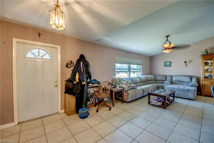 Living room with light tile patterned floors and vaulted ceiling