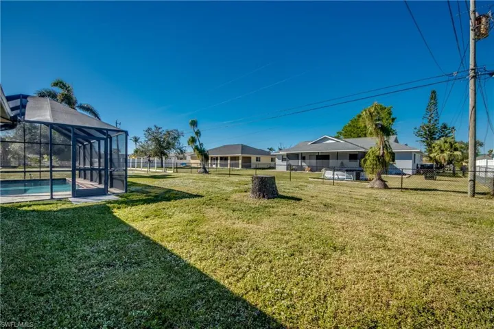 View of yard with a fenced in pool and glass enclosure