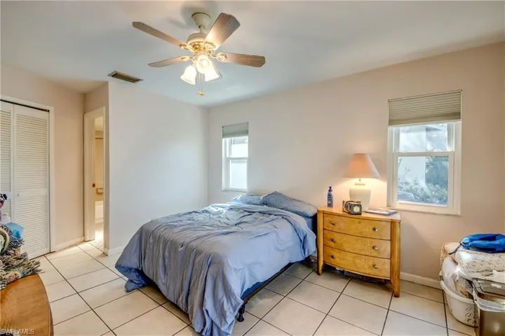 Bedroom with ceiling fan, a closet, and light tile patterned flooring