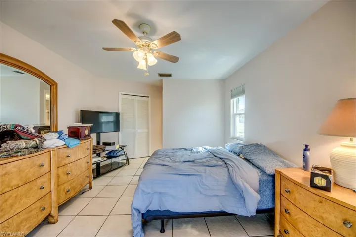 Bedroom featuring ceiling fan, light tile patterned flooring, and a closet