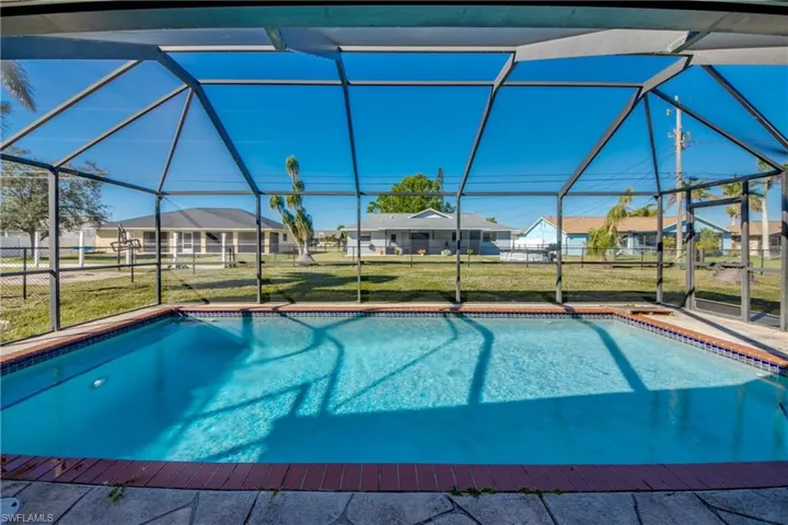 View of pool featuring a lanai and a lawn