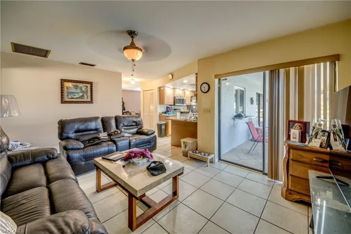 Living room featuring light tile patterned floors, plenty of natural light, and ceiling fan