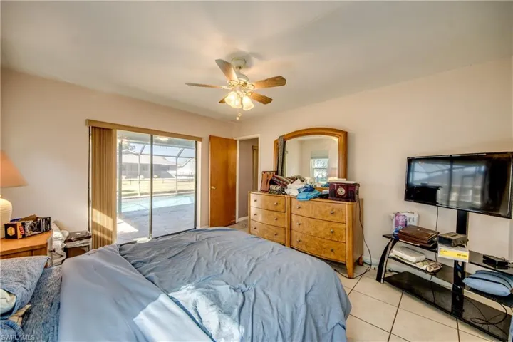 Bedroom featuring access to exterior, light tile patterned floors, and ceiling fan