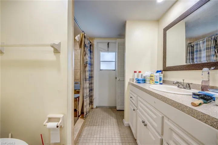 Bathroom featuring tile patterned flooring, vanity, and a shower with shower curtain
