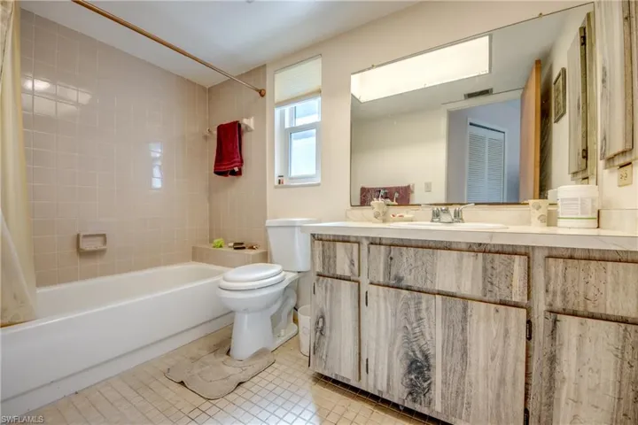 Full bathroom with tile patterned flooring, vanity, toilet, and shower / tub combo