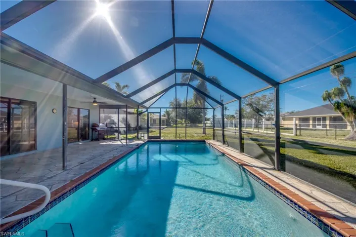 View of pool with ceiling fan, a lanai, and a patio