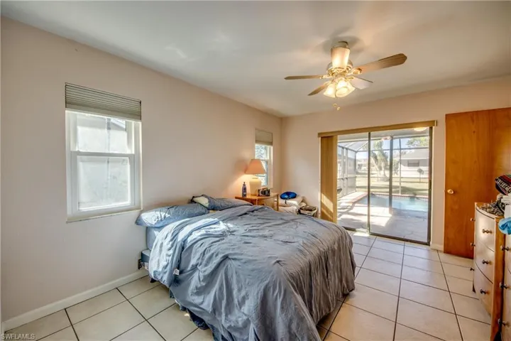 Tiled bedroom featuring access to exterior and ceiling fan