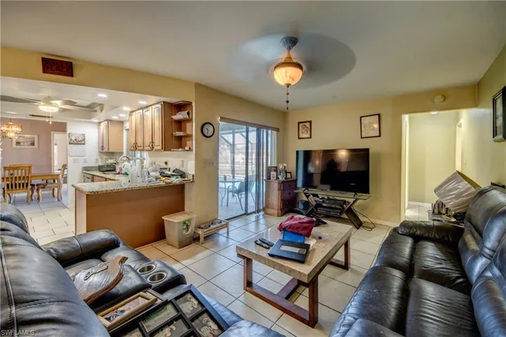 Tiled living room featuring ceiling fan and sink