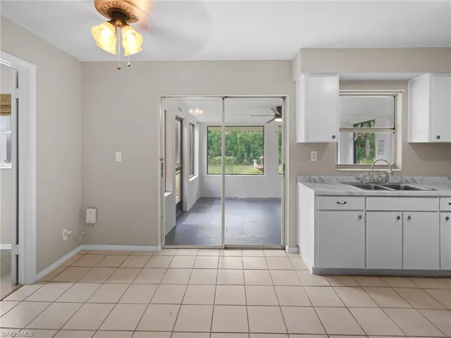 Kitchen with a ceiling fan, light countertops, white cabinetry, and light tile patterned floors