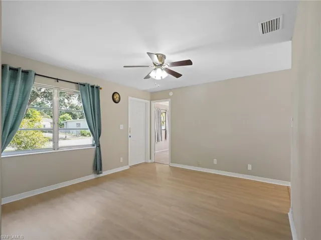 Empty room with light wood finished floors and ceiling fan