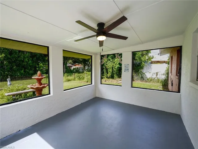 Unfurnished sunroom featuring a textured wall and finished concrete floors