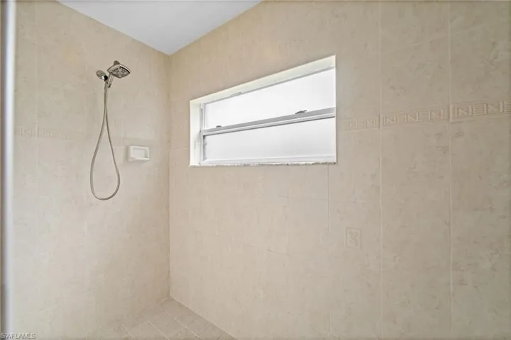 The primary bathroom showcases a very large, walk-in tiled shower.