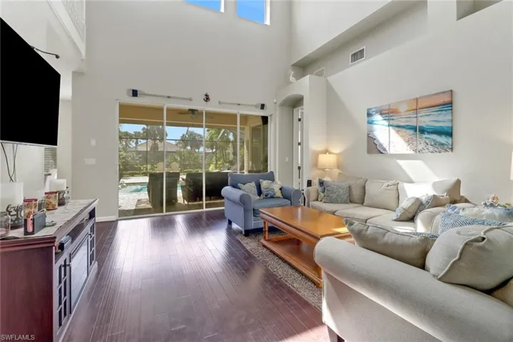 Living room with a towering ceiling and dark wood-type flooring