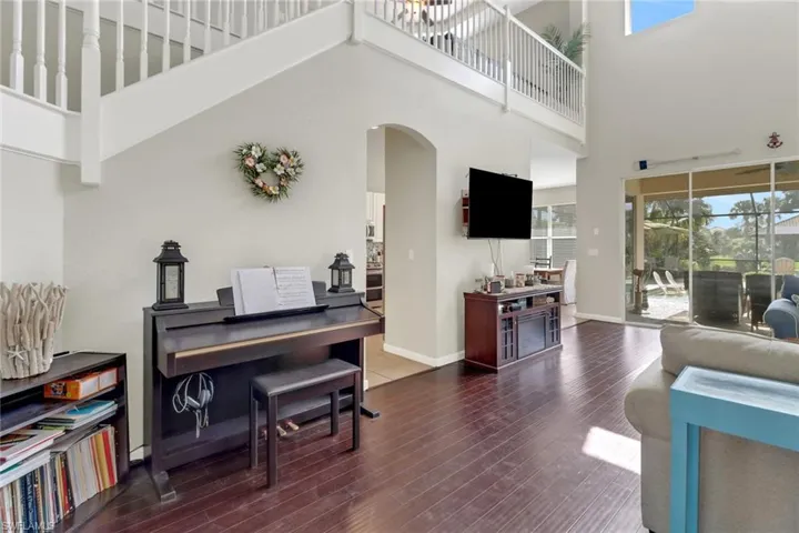 Living room featuring dark wood-type flooring and a high ceiling